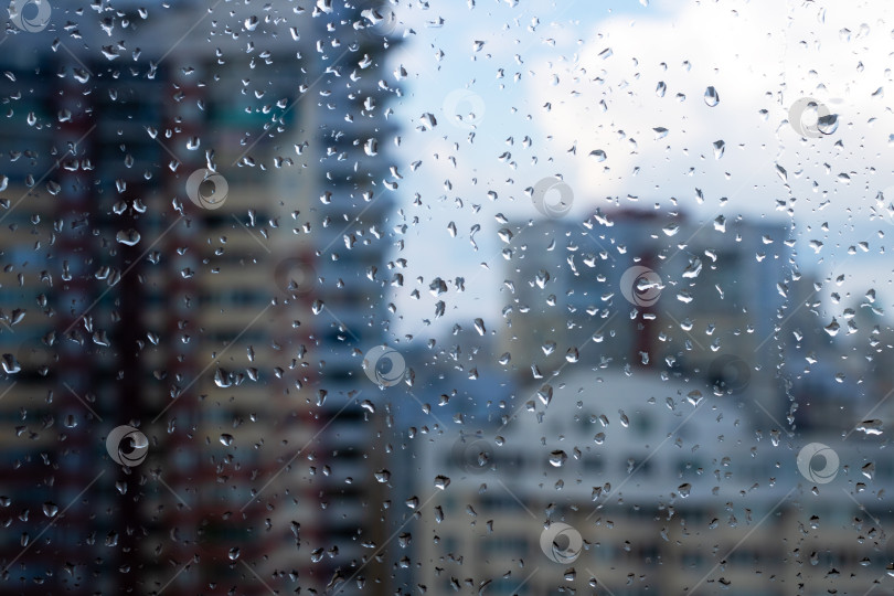 Скачать Капли дождя мягко падают на окно на фоне зданий фотосток Ozero