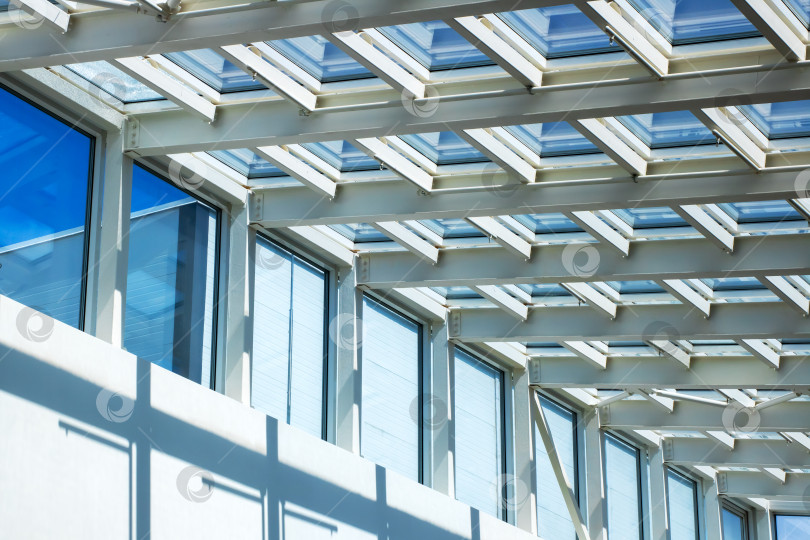 Скачать Здание с многочисленными окнами, расположенное на фоне солнечного голубого неба фотосток Ozero