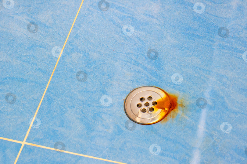 Скачать На полу, выложенном голубой плиткой, находится ржавый водосток фотосток Ozero