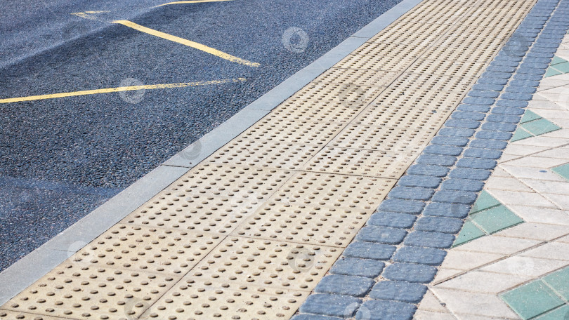 Скачать Подробный вид кирпичной дорожки, расположенной вплотную к дороге, крупным планом фотосток Ozero