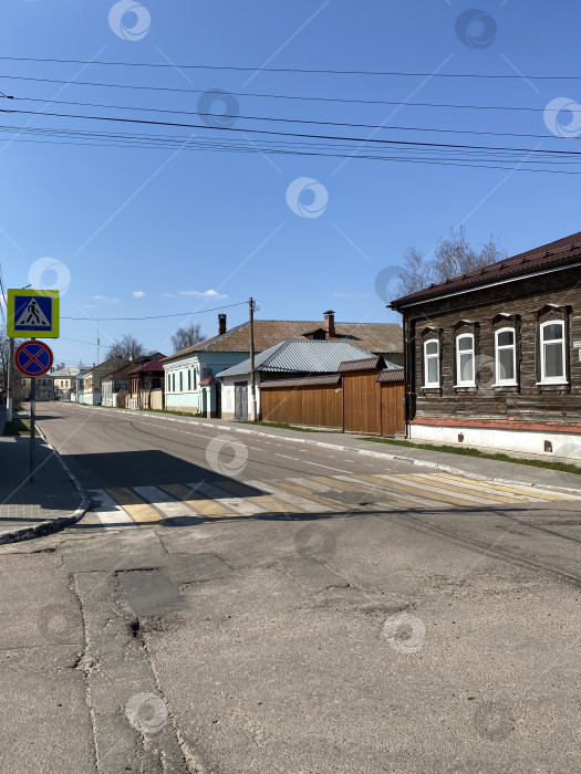 Скачать Вид на городскую улицу с традиционными деревянными домами и ясным голубым небом, подходящий в качестве фона фотосток Ozero