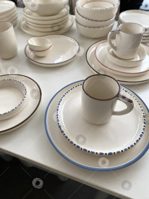 Скачать На выставке представлена керамическая посуда с минималистичным дизайном, включающая тарелки, миски и кружки фотосток Ozero