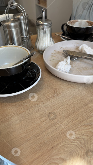 Скачать Пустые кофейные чашки и грязные тарелки на деревянном столике кафе после еды фотосток Ozero