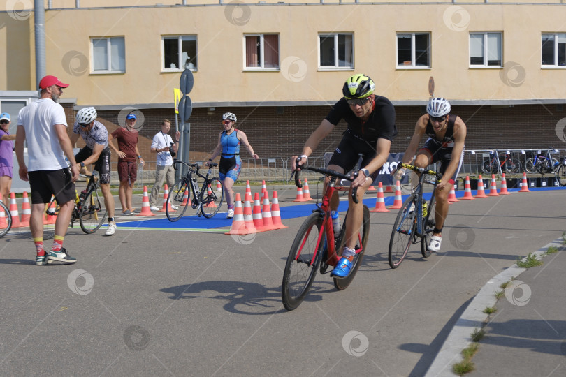 Скачать На дистнции. Соревнования по триатлону. Велосипедисты на дорожке. фотосток Ozero