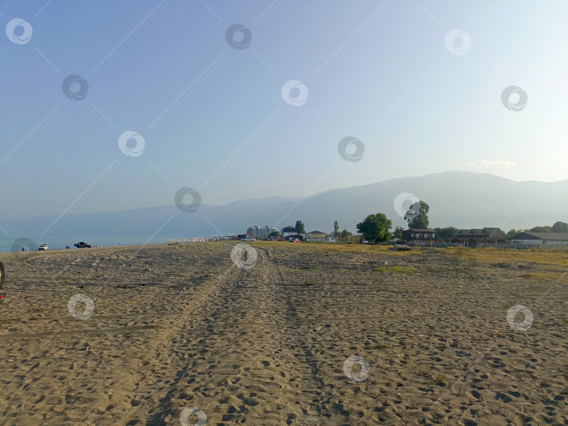 Скачать Широкий живописный пляж в реалистичном стиле в синих и бежевых тонах, представляющий собой место для отдыха на море и путешествий с пространством для копирования фотосток Ozero