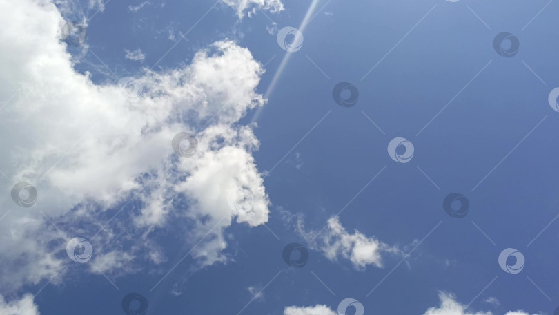 Скачать Плавное движение белых облаков по голубому небу: успокаивающая горизонтальная анимация фотосток Ozero