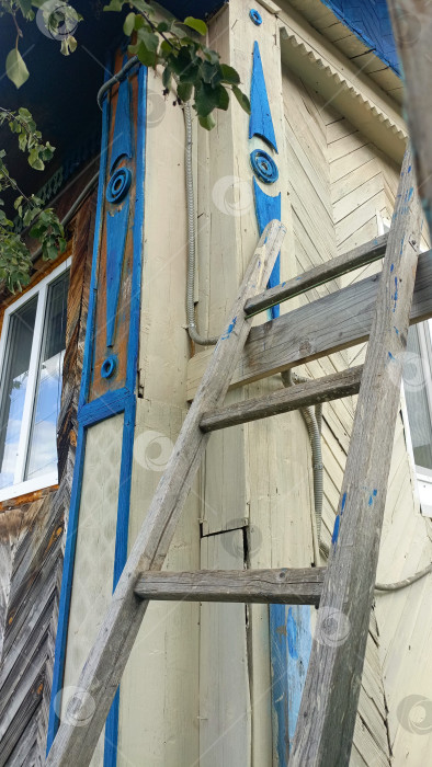 Скачать Выветрившееся деревянное здание с декоративно-прикладным народным искусством и лестницей, представляющей деревенскую архитектуру фотосток Ozero