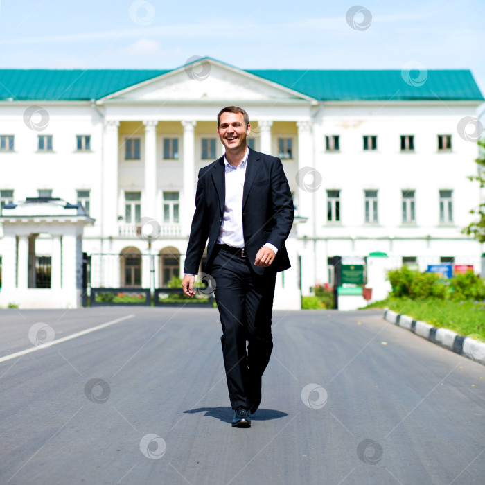 Скачать Портрет молодого бизнесмена в полный рост, идущего по дороге фотосток Ozero
