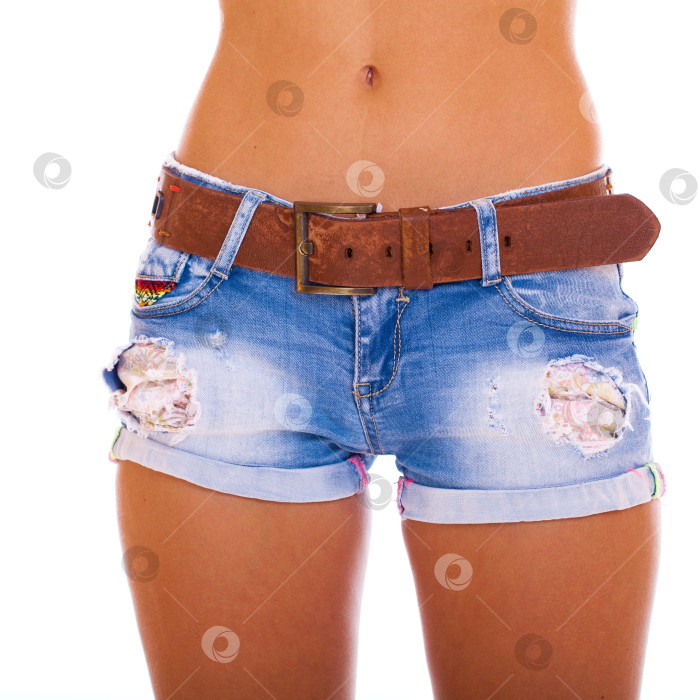 Скачать Молодая загорелая женщина в синих коротких джинсах на белом фоне фотосток Ozero