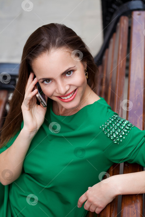 Скачать Молодая женщина сидит на скамейке фотосток Ozero