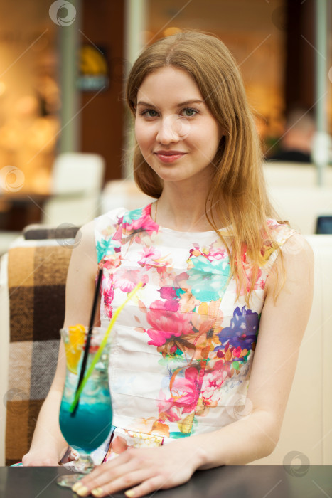 Скачать Молодая женщина пьет коктейль в кафе фотосток Ozero