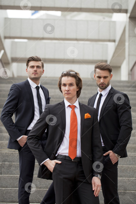 Скачать Трое молодых людей в элегантных деловых костюмах фотосток Ozero