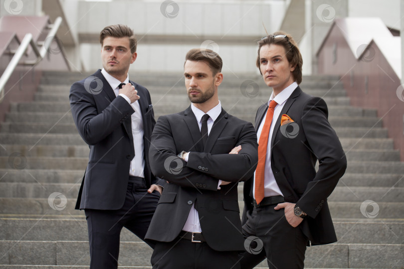 Скачать Трое молодых людей в элегантных деловых костюмах фотосток Ozero