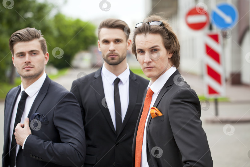 Скачать Трое молодых людей в элегантных деловых костюмах фотосток Ozero