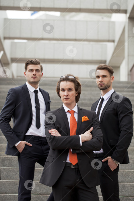 Скачать Трое молодых людей в элегантных деловых костюмах фотосток Ozero