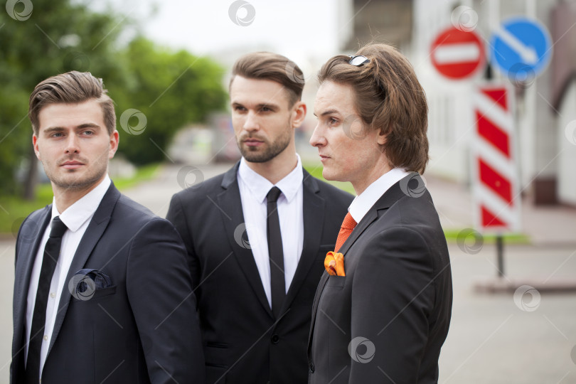 Скачать Трое молодых людей в элегантных деловых костюмах фотосток Ozero