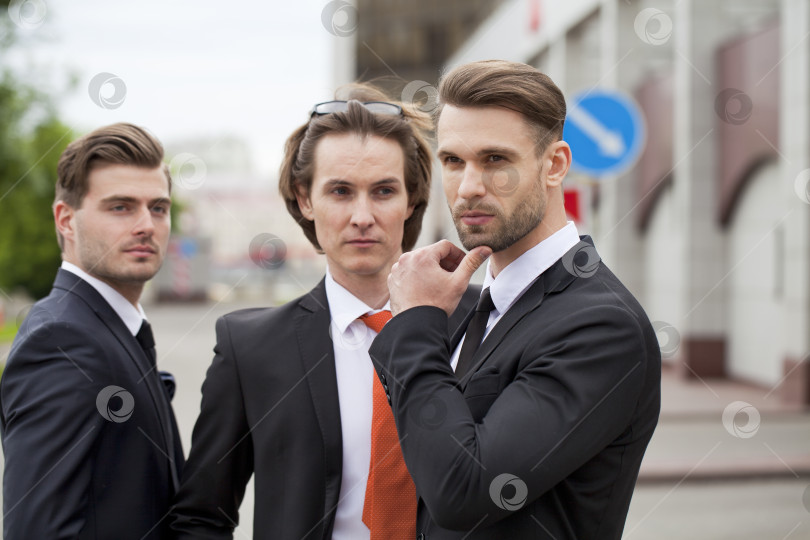Скачать Трое молодых людей в элегантных деловых костюмах фотосток Ozero