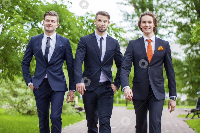 Скачать Трое молодых людей в элегантных деловых костюмах фотосток Ozero