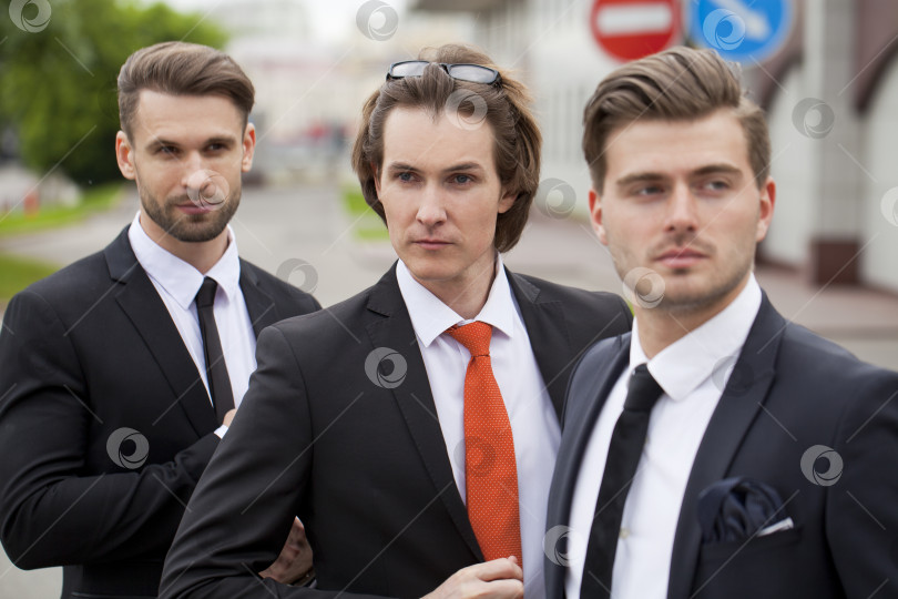 Скачать Трое молодых людей в элегантных деловых костюмах фотосток Ozero