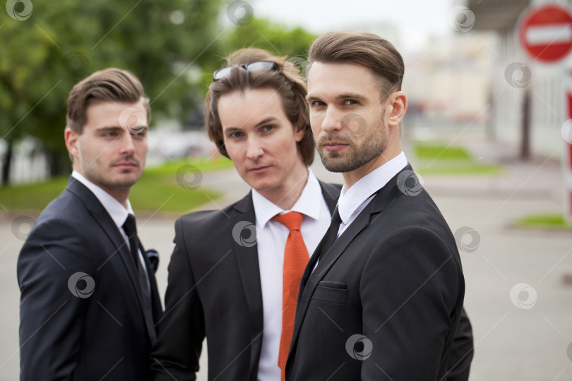 Скачать Трое молодых людей в элегантных деловых костюмах фотосток Ozero