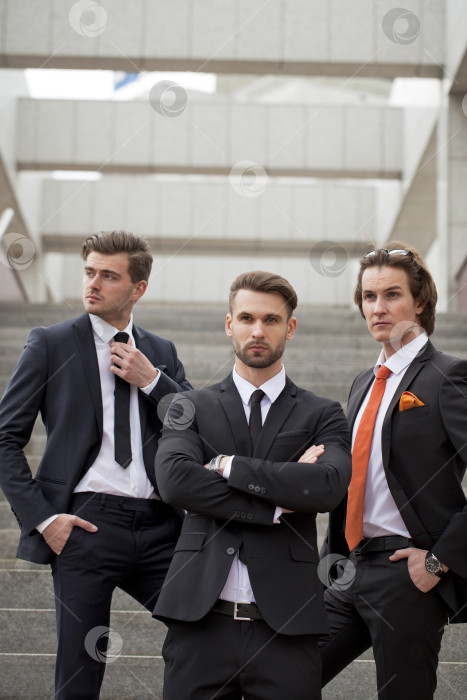 Скачать Трое молодых людей в элегантных деловых костюмах фотосток Ozero