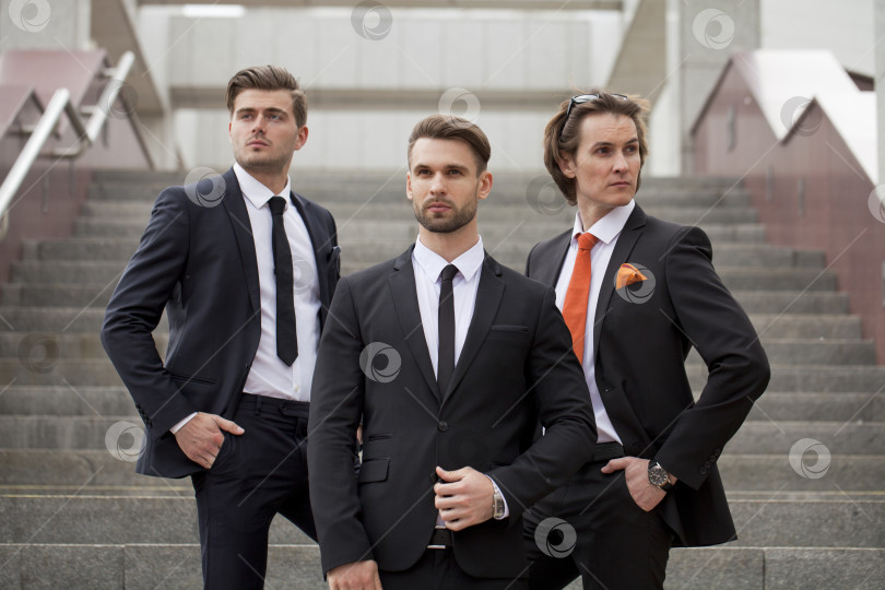 Скачать Трое молодых людей в элегантных деловых костюмах фотосток Ozero