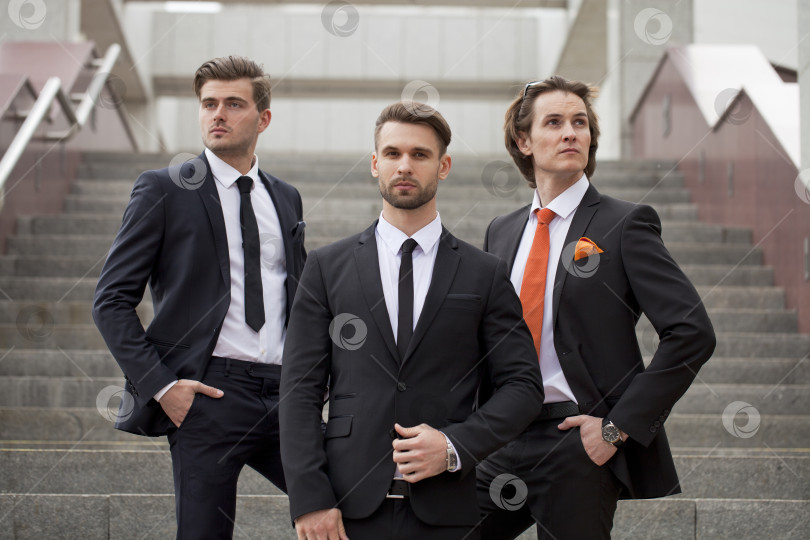 Скачать Трое молодых людей в элегантных деловых костюмах фотосток Ozero
