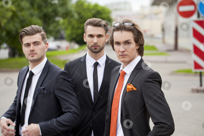 Скачать Трое молодых людей в элегантных деловых костюмах фотосток Ozero