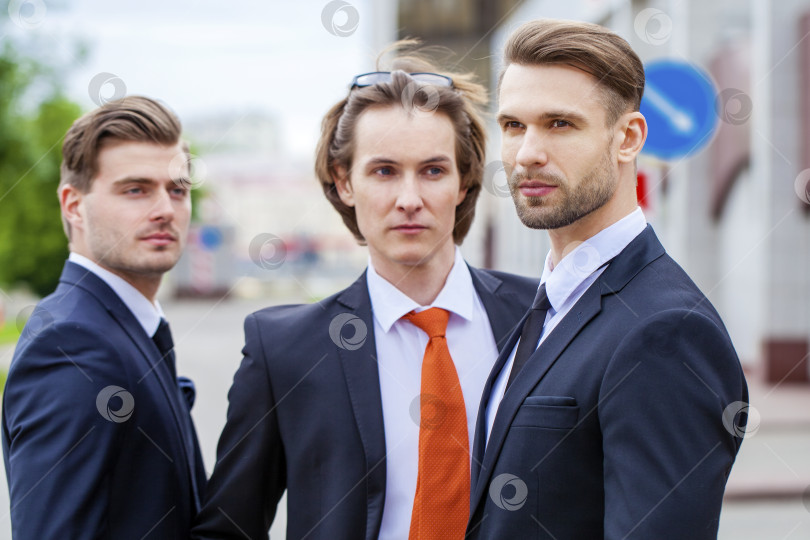 Скачать Трое молодых людей в элегантных деловых костюмах фотосток Ozero