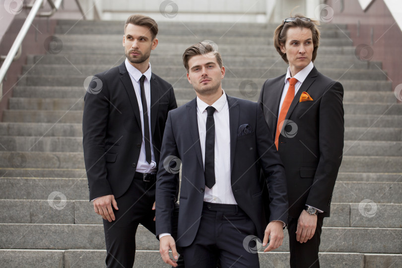 Скачать Трое молодых людей в элегантных деловых костюмах фотосток Ozero
