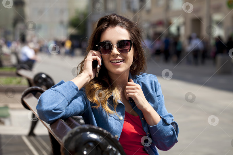 Скачать Молодая брюнетка звонит по телефону фотосток Ozero