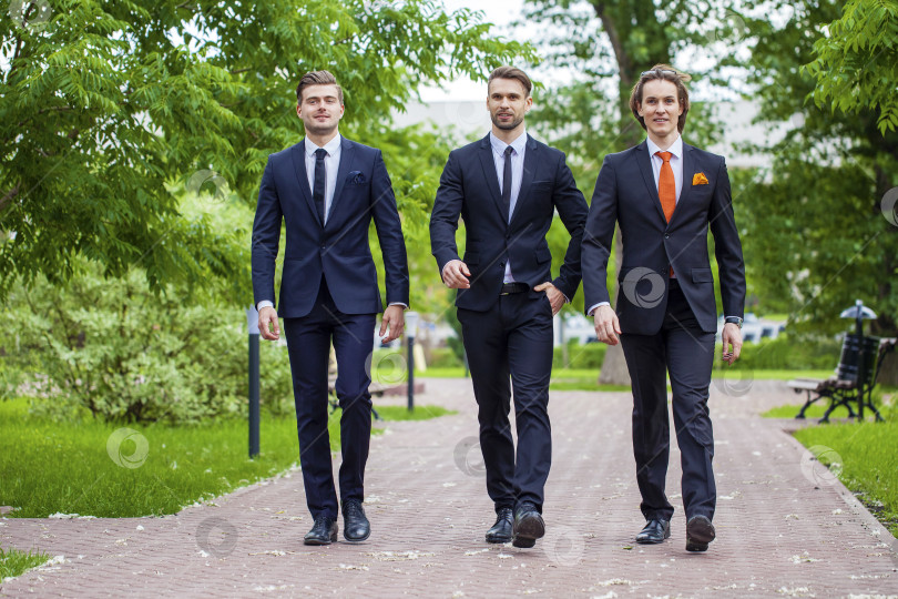 Скачать Трое молодых людей в элегантных деловых костюмах фотосток Ozero