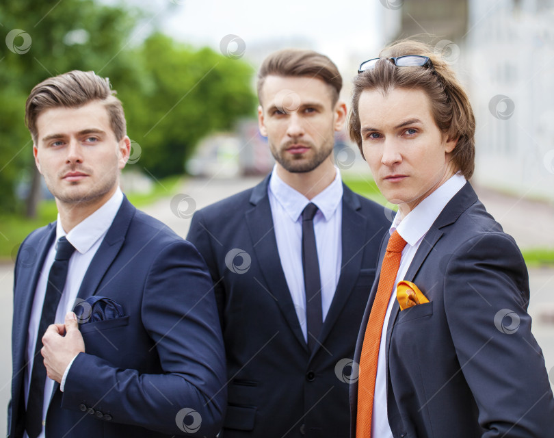 Скачать Трое молодых людей в элегантных деловых костюмах фотосток Ozero