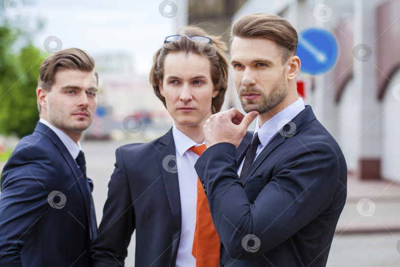 Скачать Трое молодых людей в элегантных деловых костюмах фотосток Ozero