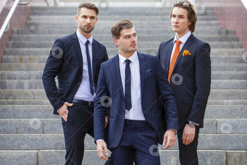 Скачать Трое молодых людей в элегантных деловых костюмах фотосток Ozero