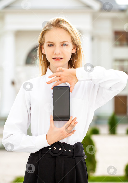 Скачать Молодая красивая девушка показывает дисплей смартфона фотосток Ozero