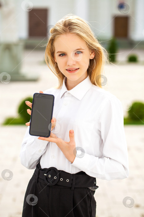 Скачать Молодая красивая девушка показывает дисплей смартфона фотосток Ozero