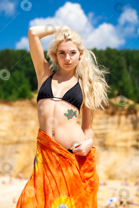 Скачать Сексуальная молодая красивая блондинка в черном бикини и красной тунике фотосток Ozero