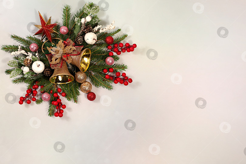 Скачать Красивое праздничное украшение из живых еловых веток и игрушек, колокольчиков, звездочек, выделенных на ярком фоне, рождественский шаблон для оформления, рождественская композиция и концепция Нового 2026 года, баннер для зимнего экрана, l фотосток Ozero
