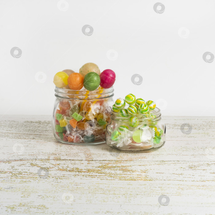 Скачать Разноцветные леденцы в стеклянных баночках на сером фоне. Смотрите прямо перед собой фотосток Ozero
