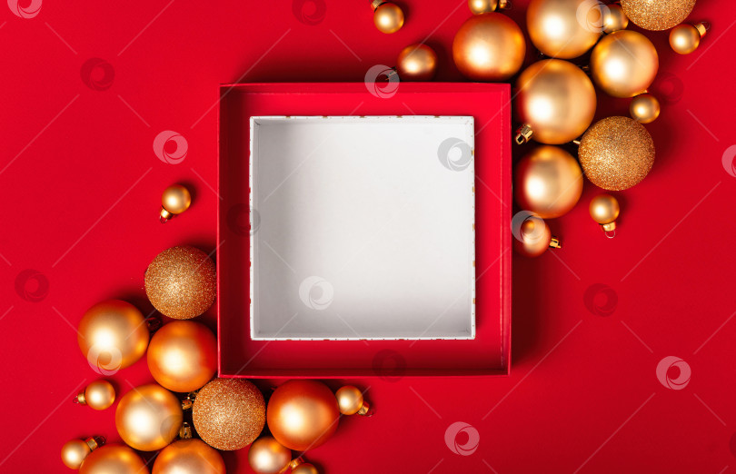 Скачать Красный фон с открытой подарочной коробкой, белая внутренняя часть и золотые украшения фотосток Ozero