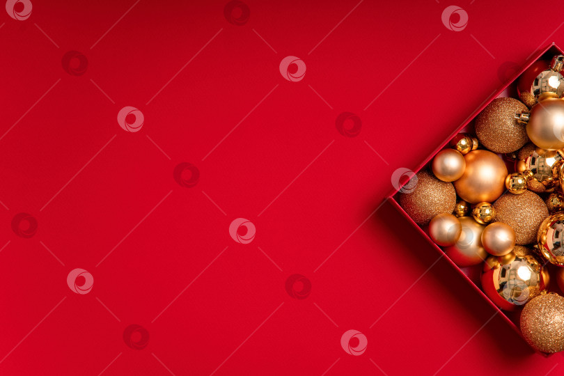 Скачать Красный рождественский фон с коробкой золотых безделушек, место для копирования фотосток Ozero