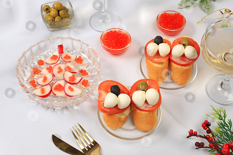 Скачать Рождественские и новогодние блюда, брускетта капрезе с сыром моцарелла, помидорами и оливками, салат из редиса и красной икры, шампанское, идеи сервировки стола и меню, концепции здорового образа жизни, фотосток Ozero