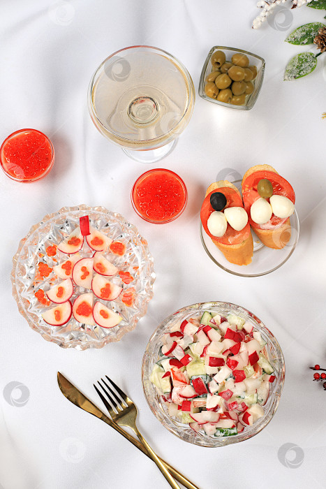 Скачать Рождественские и новогодние блюда, брускетта капрезе с сыром моцарелла, помидорами и оливками, салат из редиса и красной икры, шампанское, идеи сервировки стола и меню, концепции здорового образа жизни, фотосток Ozero