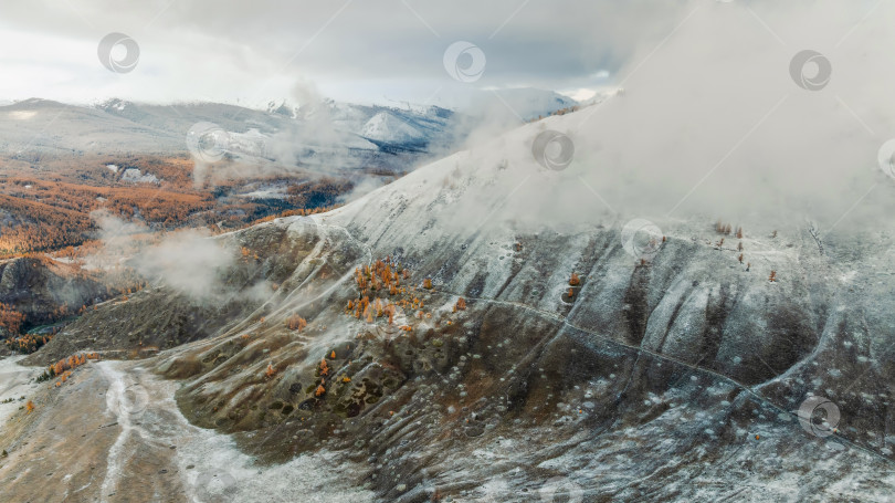 Скачать Удивительный вид с высоты птичьего полета на низкие снежные облака, ползущие по склонам гор фотосток Ozero