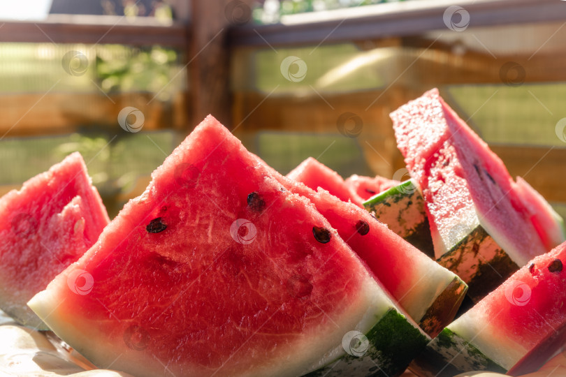Скачать На столе свежий нарезанный ломтиками красный и сочный арбуз.  фотосток Ozero