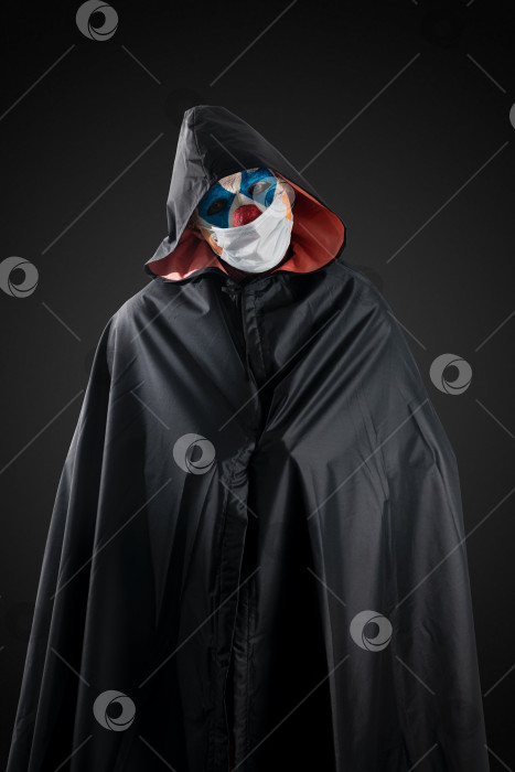 Скачать Клоун на темном фоне в медицинской маске. фотосток Ozero