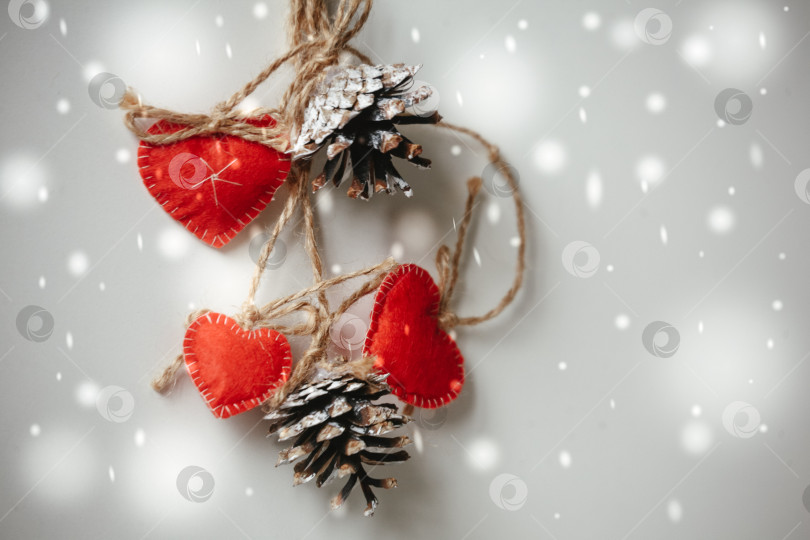 Скачать Зимняя открытка с красными сердечками и сосновыми шишками фотосток Ozero