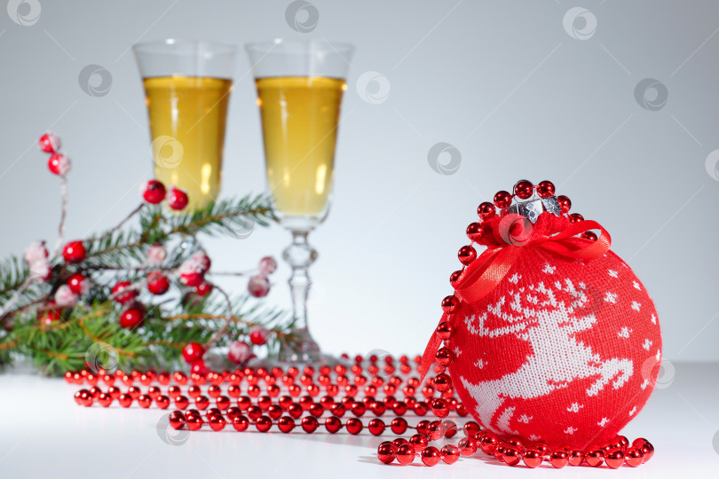 Скачать Бокалы с вином и красный шар на сером фоне. Новогодняя открытка фотосток Ozero