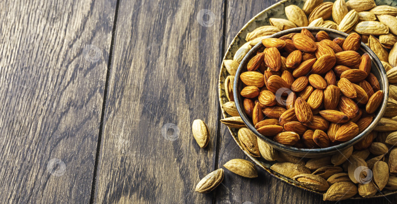 Скачать Миска с миндалем на деревянном столе с местом для копирования фотосток Ozero